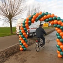 fietsen door een ballonnenboog voor opening nieuw fietspad